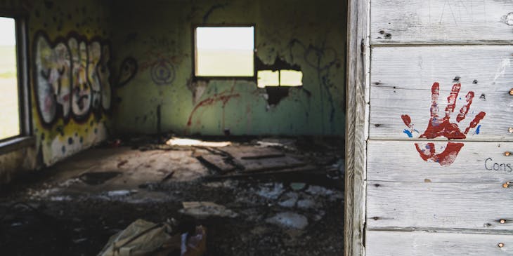 A creepy escape room with a red hand print on the wall.