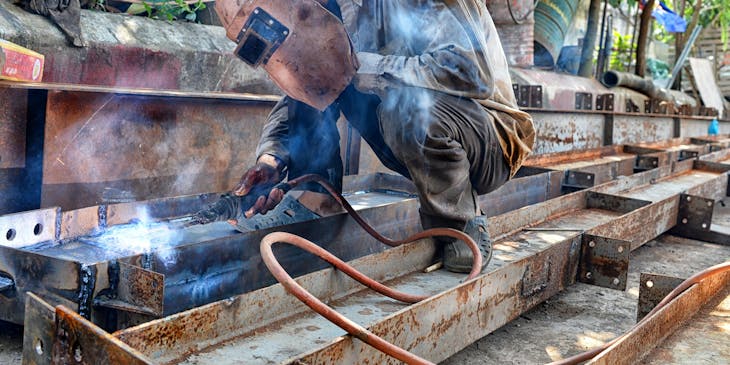 A welder working on the fabrication of steel girders.
