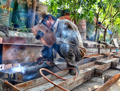 A welder working on the fabrication of steel girders.