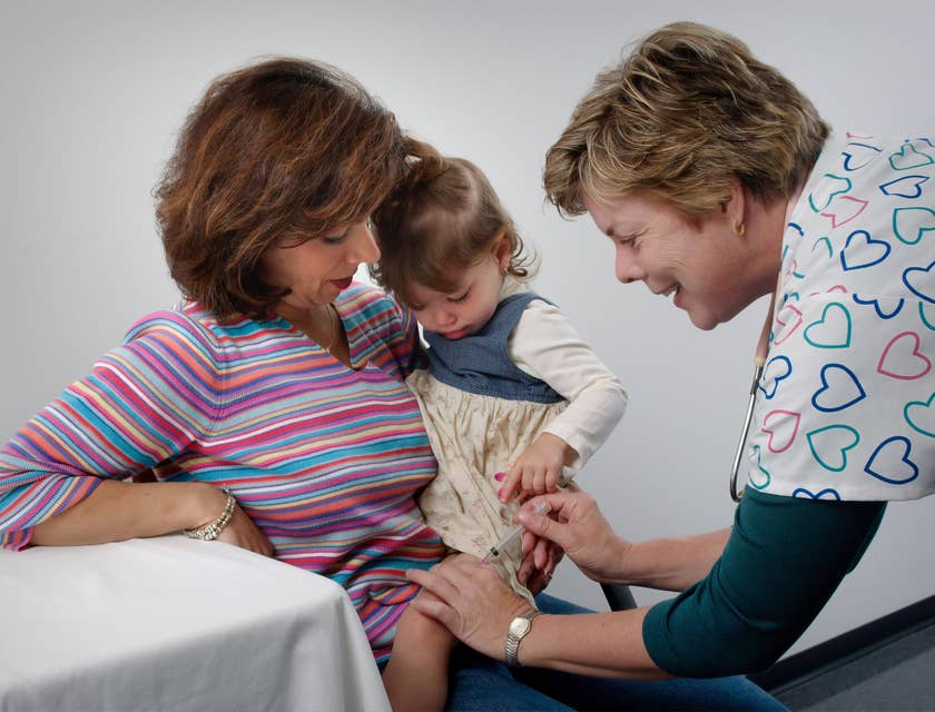 Uma enfermeira administra uma injeção em uma criança em uma clínica da família.