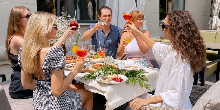 A group of friends and family clinking their glasses over a meal at a family restaurant.