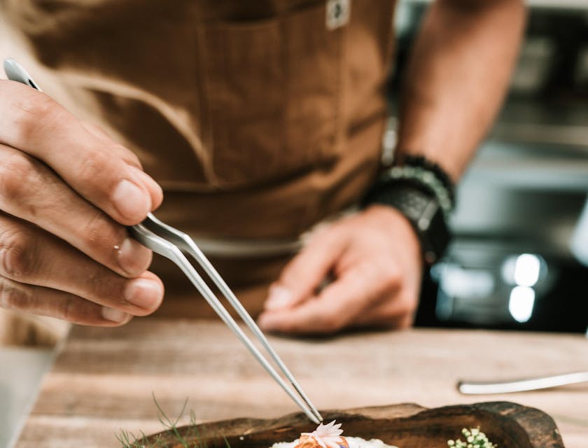 A chef adding the finer details to a fancy restaurant meal.