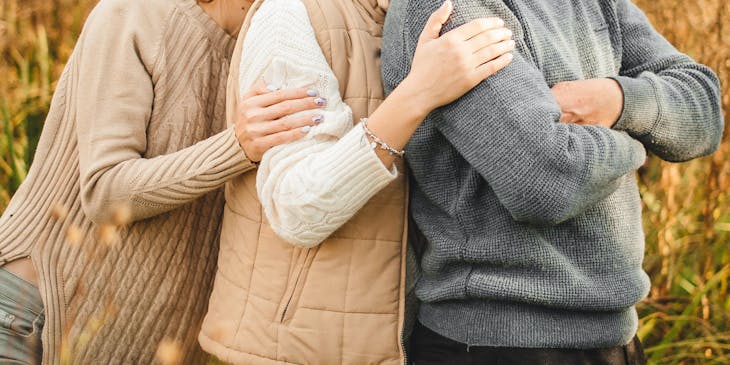 A father being embraced by his two daughters.