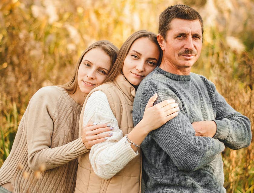 A father being embraced by his two daughters.