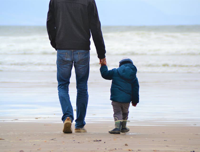 Father and son walking on a beach.