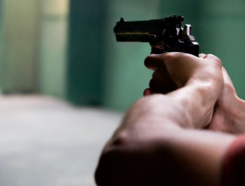 Personne qui tient une arme.