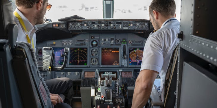 A pilot and first officer in the flight deck of an airplane.