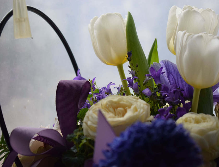 Arranjo floral com fita roxa criado pelo designer floral.