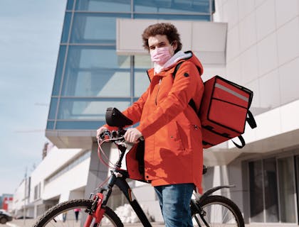 Entregador de delivery de comida com sua bicicleta.