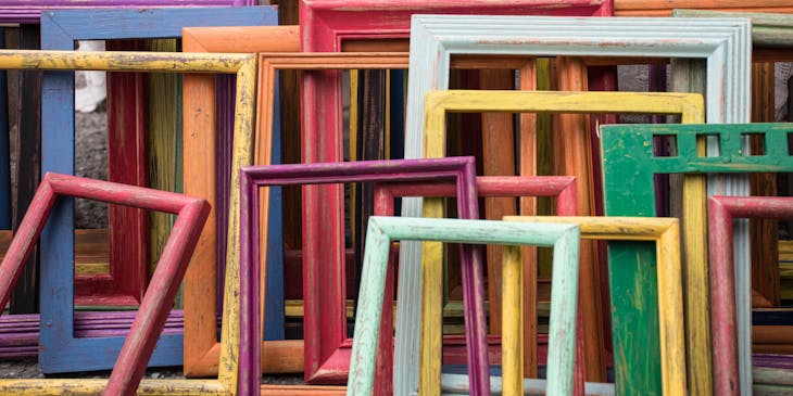 Colorful frames lying stacked against each other.