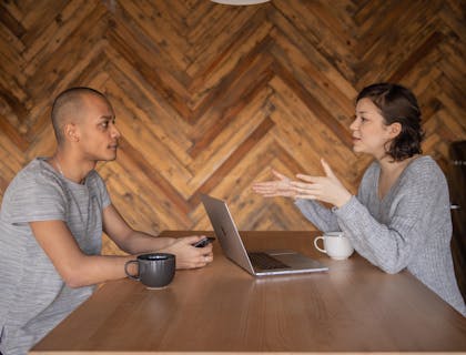 Une rédactrice freelance discute d'un dossier avec un client.