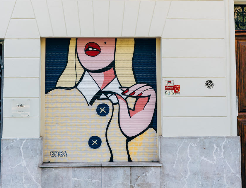 Prédio com um grafite descolado de uma mulher.