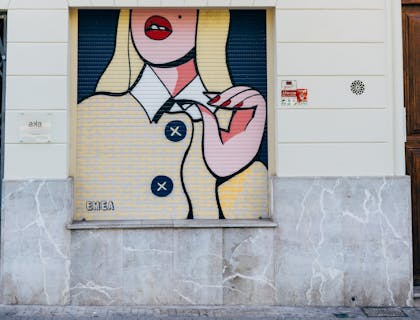 Edificio con una pintura afuera de un negocio con nombre funky.