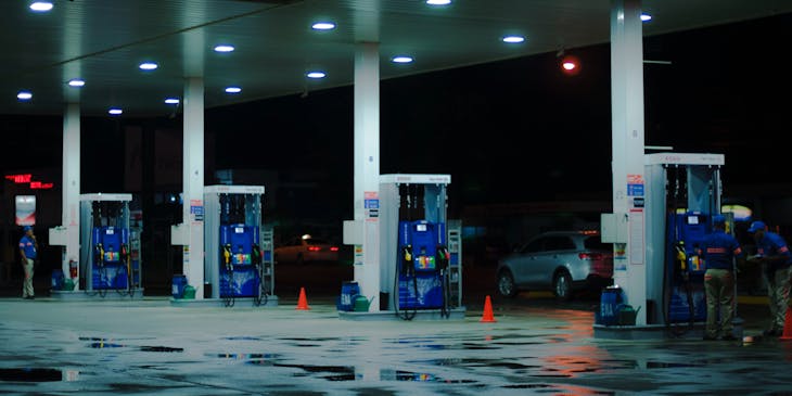 A blue and white gas station with attendants.