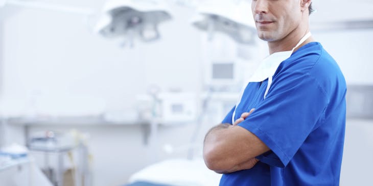 A gastroenterologist stands inside an operating theater in a hospital.