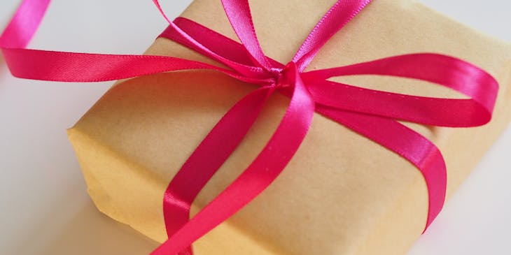A box wrapped in brown paper and decorated with a pink ribbon.