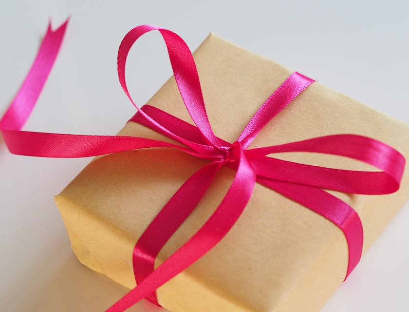 A box wrapped in brown paper and decorated with a pink ribbon.