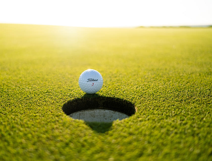 Ein Golfball liegt auf dem Putting Green eines Golfplatzes.