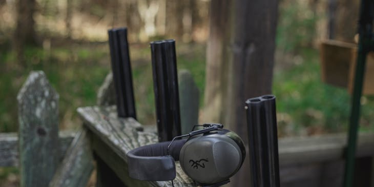 Headphones resting on a gun rack at a gun/rifle range.