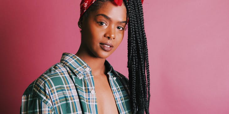 Woman wearing a bandana against a pink background.
