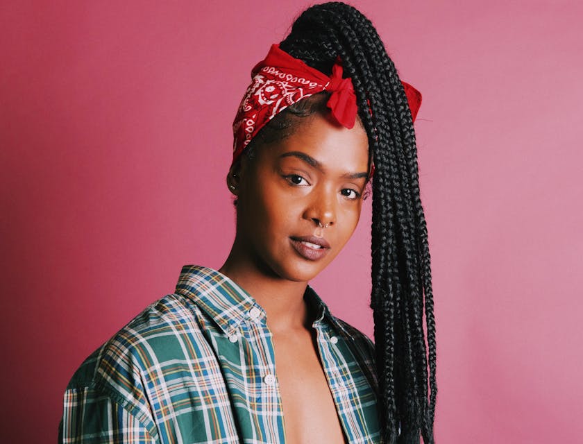 Mulher usando um acessório de cabelo na frente de um fundo rosa.