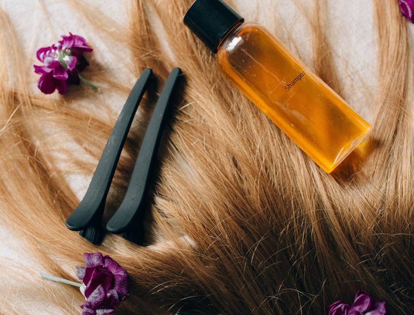 Dei prodotti per la cura dei capelli poggiati su dei capelli biondi.