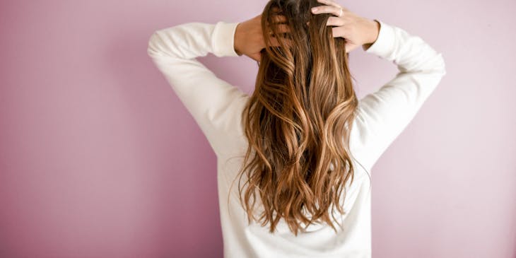 Person running their fingers through their hair after using hair products.