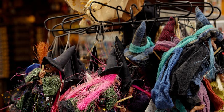 Small witch toys on hangers in a Halloween store.