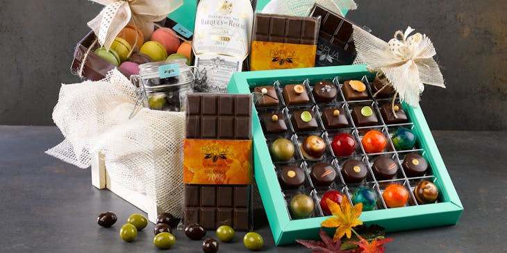 A hamper filled with chocolate, wine, and other items.