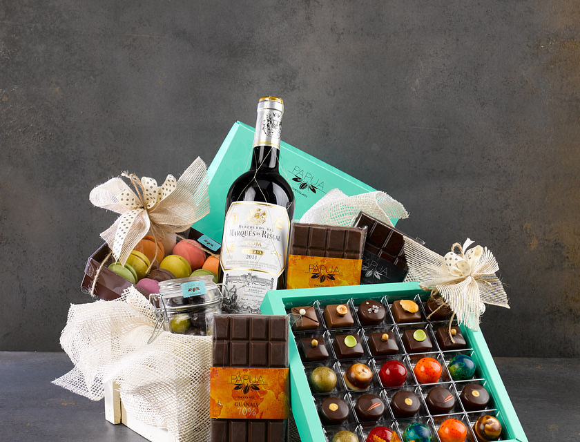 A hamper filled with chocolate, wine, and other items.