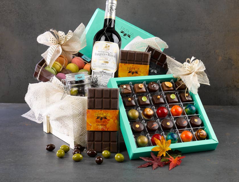 A hamper filled with chocolate, wine, and other items.