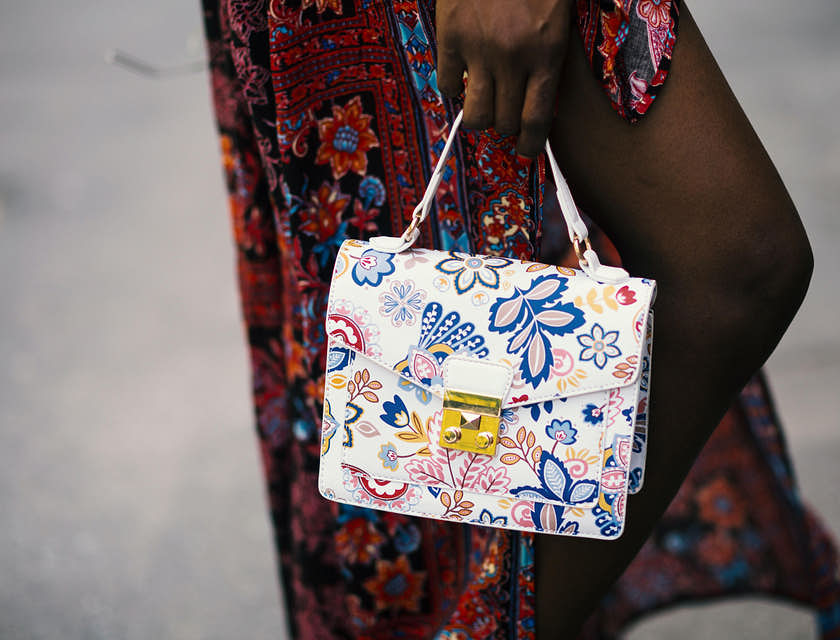 Uma pessoa segurando uma bolsa de mão branca comprada em uma loja de bolsas de mão.