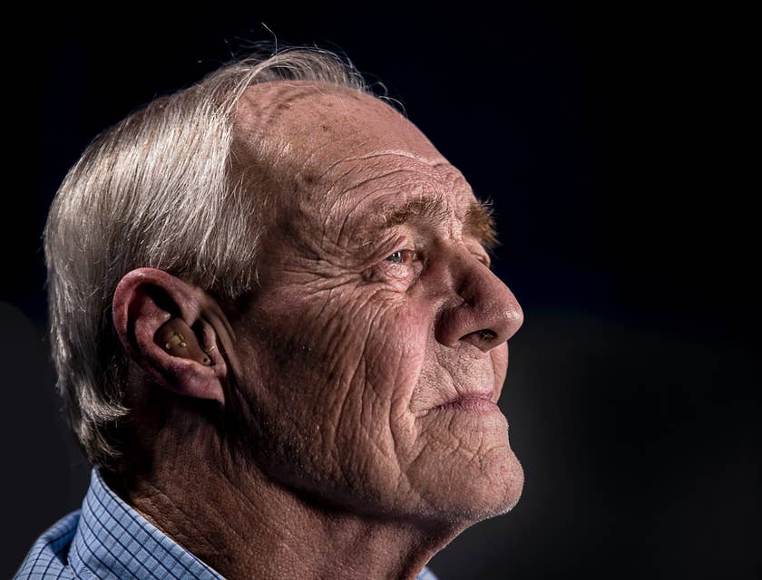 Un uomo anziano che indossa un apparecchio acustico.