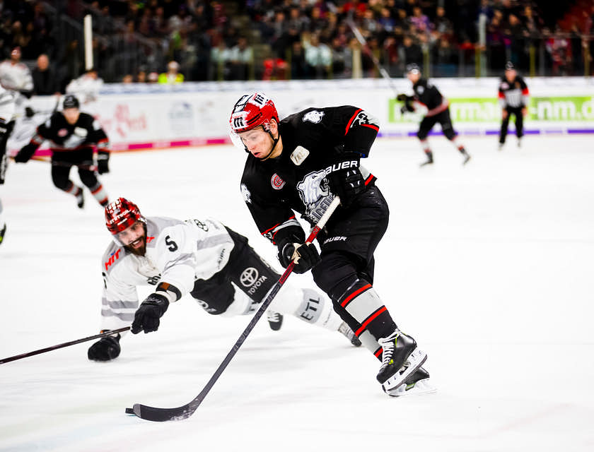 Jogo de hockey com jogadores usando equipamentos.