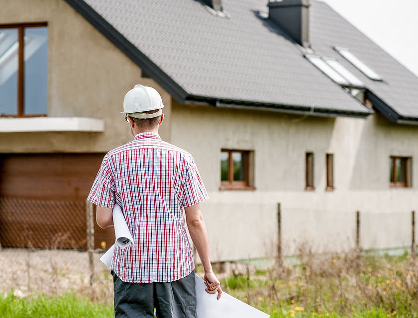 Architect walking towards newly built home.