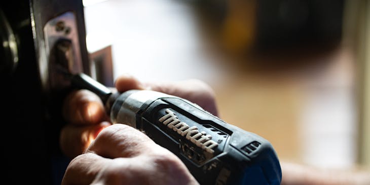 A person holding a power drill for home repair purposes.