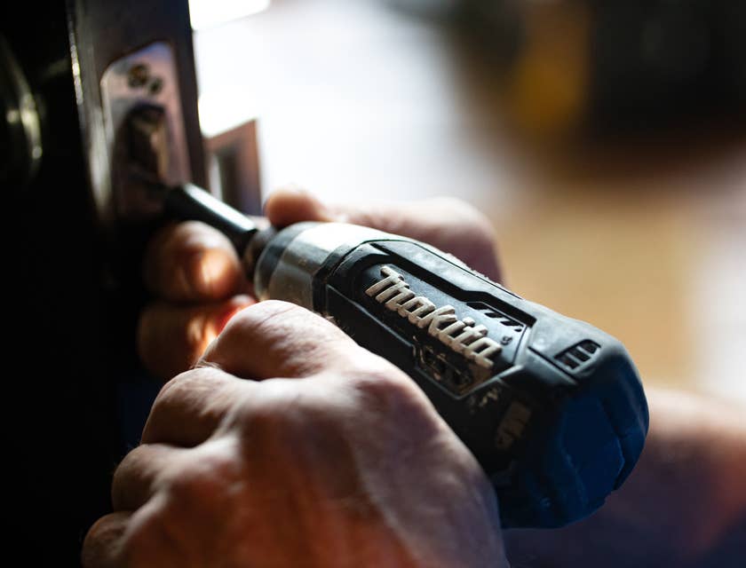 A person holding a power drill for home repair purposes.