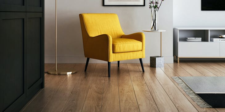 A staged living room with a bright yellow couch.