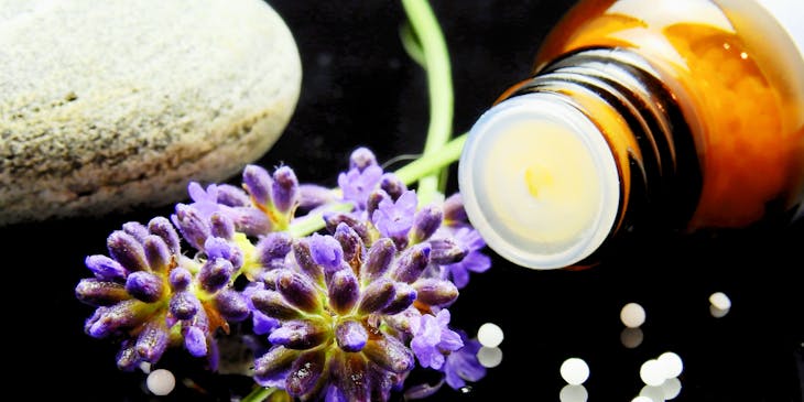 Display of herbal extracts and remedies in glass containers on a table in a homeopathic setting.