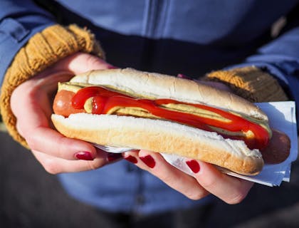 Mains d'une cliente avec un hot-dog.