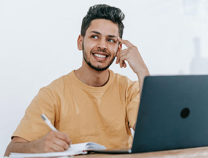 A man sitting at a desk thinking about a brand name idea.