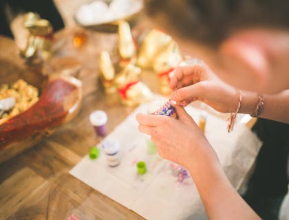 woman's hands working on beaded decoration