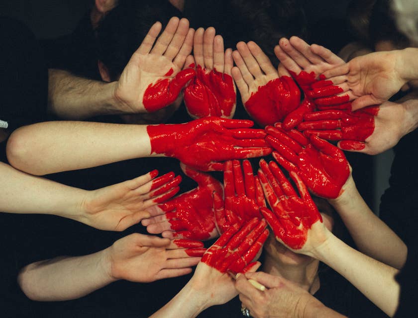 many hands together with red heart painted on them