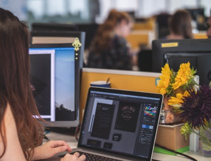 woman working on graphic design on laptop