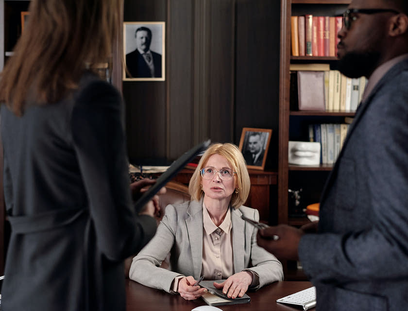 people in formal clothing around conference table