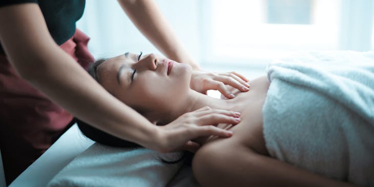 massage therapist doing a palm massage on the client's shoulders in a massage business