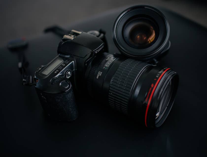 Una cámara Canon y un lente sobre un fondo negro en un negocio de fotografía.