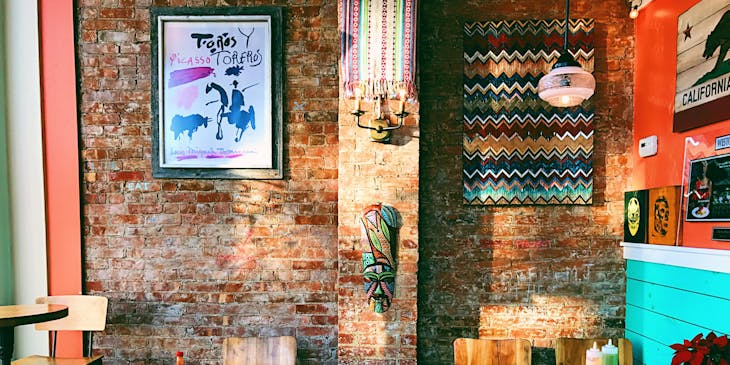 Empty tables in front of a face brick wall.