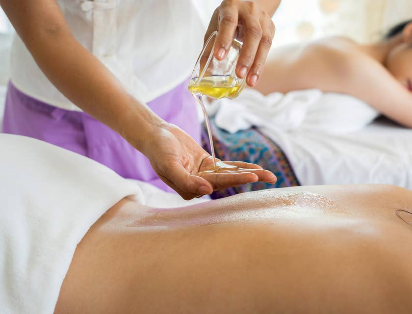 Un terapeuta dando un masaje con aceite en un spa.