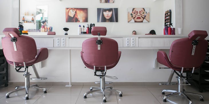 Des sièges vides dans un salon de coiffure.